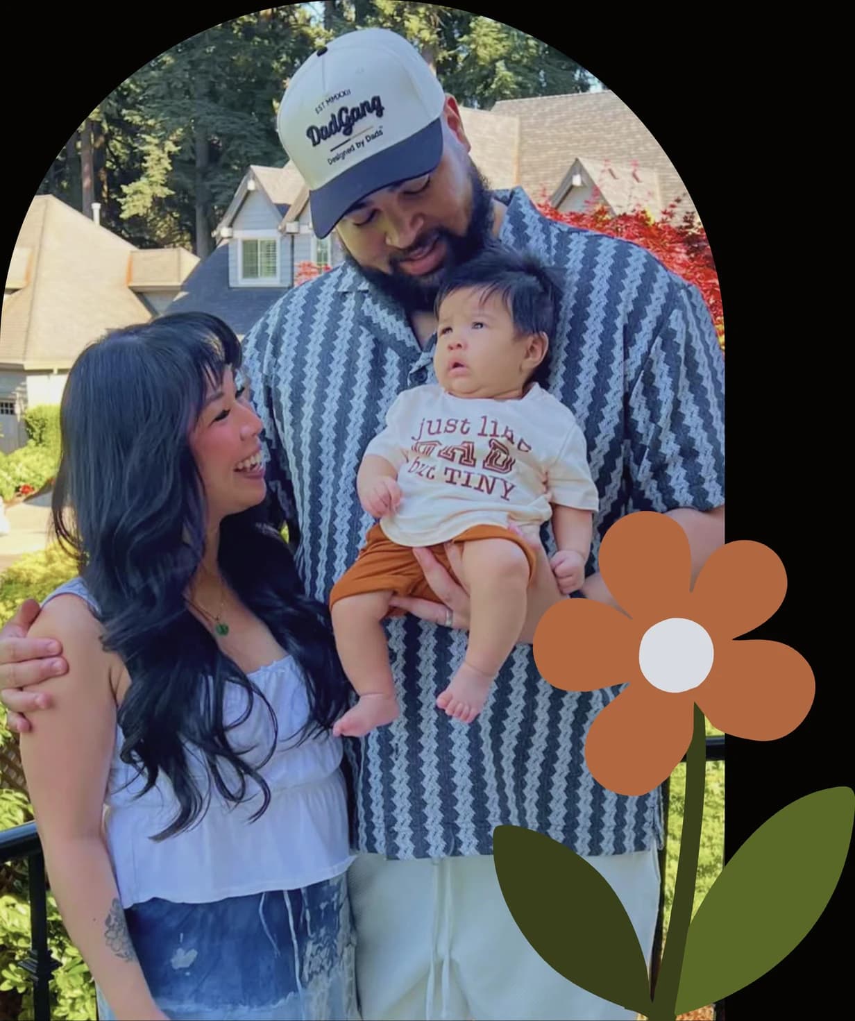 Russell holding his baby and looking down at them, his wife beside him looking up, framed in the same arch as the portrait with an orange flower in front